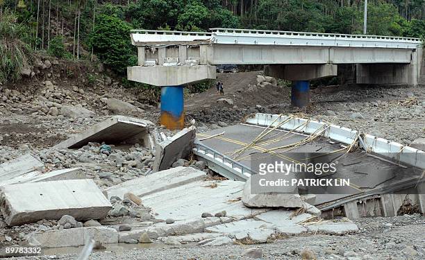 Couple by a collapsed bridge at the village of Meishan in Chiayi county, southern Taiwan, on August 14, 2009. Rescuers in Taiwan on August 14 battled...