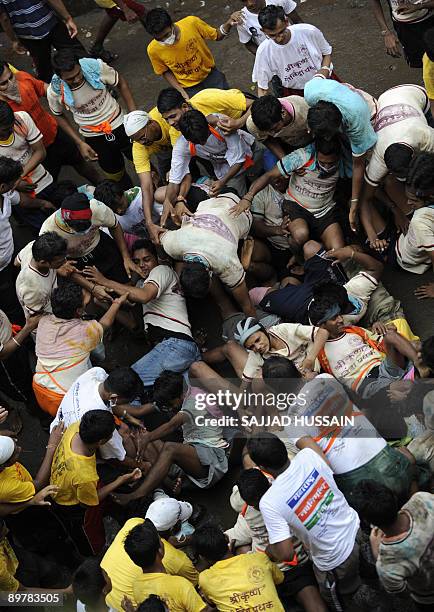 Young Indian devotee of Hindu God, Lord Krishna fall while attempting to break a 'dahi-handi' during a festival in Mumbai on August 14 as part of...