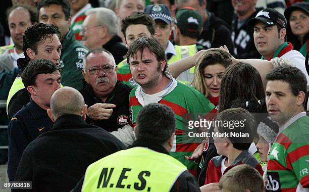 Rabbitohs supporter is taken by security and police after abusing the referees during the round 23 NRL match between the South Sydney Rabbitohs and...