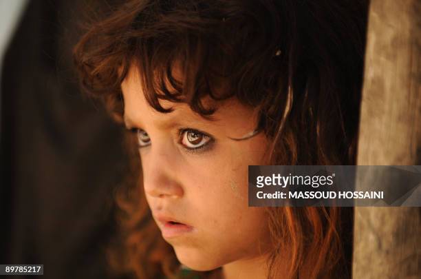 An Afghan girl looks on during a campaigning event of Afghan presidential candidate and former finance minister Ashraf Ghani in Maymana city of the...