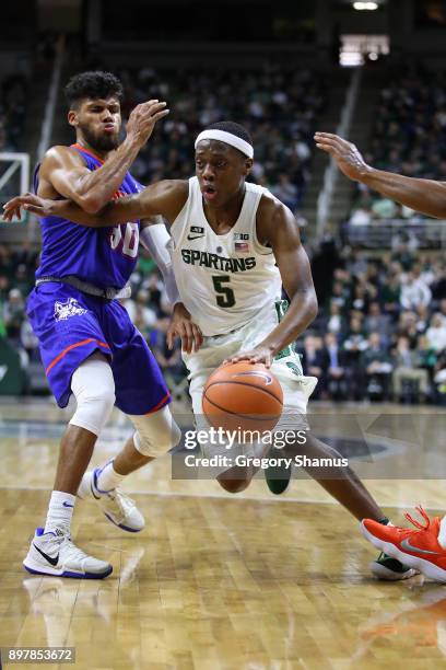Cassius Winston of the Michigan State Spartans dribbles against against the Houston Baptist Huskies at the Jack T. Breslin Student Events Center on...