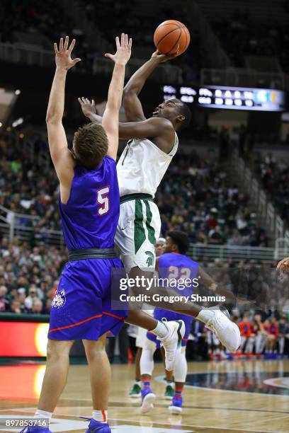 Joshua Langford of the Michigan State Spartans takes a shot over David Caraher of the Houston Baptist Huskies during the second half at the Jack T....