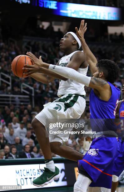 Cassius Winston of the Michigan State Spartans drives to the basket past Braxton Bonds of the Houston Baptist Huskies during the second half at the...