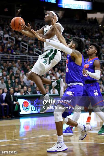 Cassius Winston of the Michigan State Spartans drives to the basket past Braxton Bonds of the Houston Baptist Huskies during the second half at the...