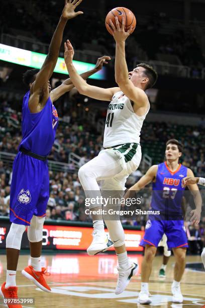 Conner George of the Michigan State Spartans drives to the basket while playing the Houston Baptist Huskies at the Jack T. Breslin Student Events...