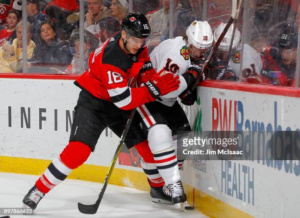 Steven Santini of the New Jersey Devils defends against Patrick Sharp of the Chicago Blackhawks on December 23, 2017 at Prudential Center in Newark,...