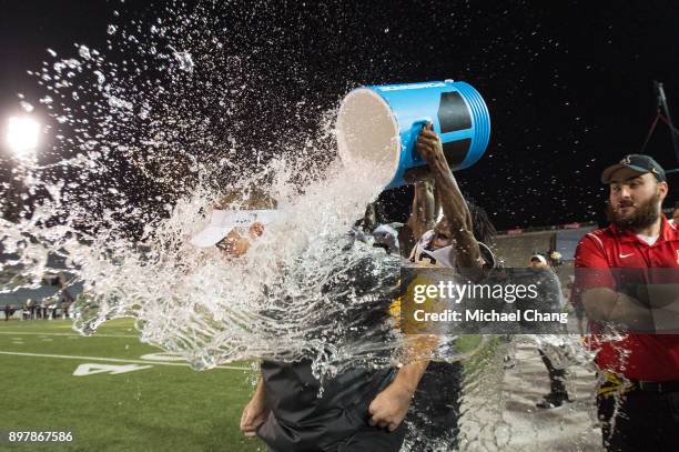 Defensive coordinator Nate Woody of the Appalachian State Mountaineers gets dunked with water after defeating the Toledo Rockets on December 23, 2017...