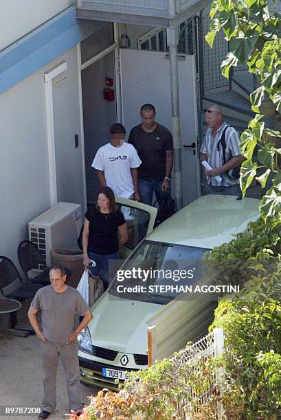 French policemen lead a French teenager , who shot and killed his parents and twin brothers, as he is leaving the courthouse of Ajaccio, on August...