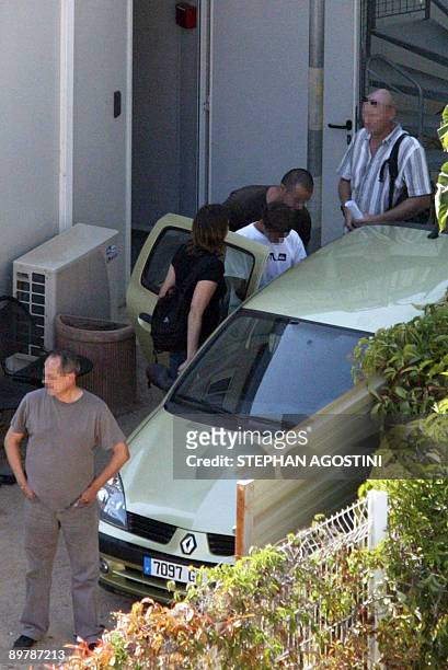 French policemen lead a French teenager , who shot and killed his parents and twin brothers, as he is leaving the courthouse of Ajaccio, on August...