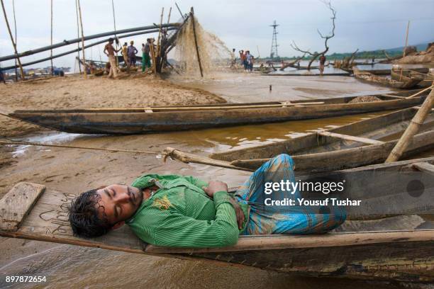 Stone laborer is sleeping on little boat at Jaflong stone quarry fileld. The crystal clear water of the Piyain River, which flows from India through...