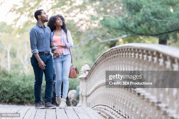 aantrekkelijke jonge paar wandeling in central park - couple central park stockfoto's en -beelden