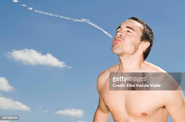 man spitting water outdoors - spit fotografías e imágenes de stock