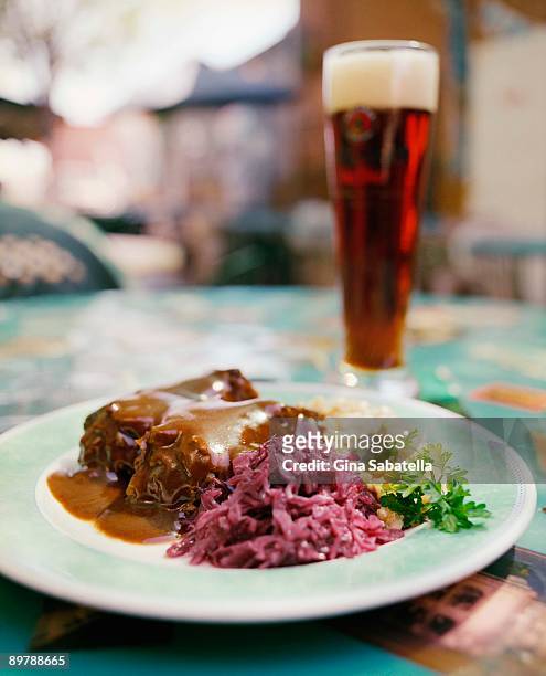 german food on plate by glass of dark beer - brown sauce foto e immagini stock