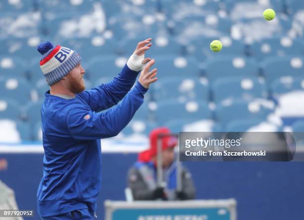 Nick O'Leary of the Buffalo Bills warms up with the help of a trainer doing hand-eye coordination drills using tennis balls before the start of NFL...