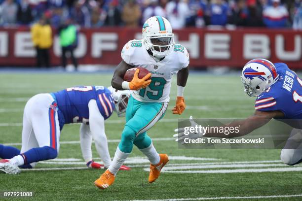 Jakeem Grant of the Miami Dolphins runs with the ball as he returns a punt during NFL game action as Joe Webb of the Buffalo Bills attempts to make a...
