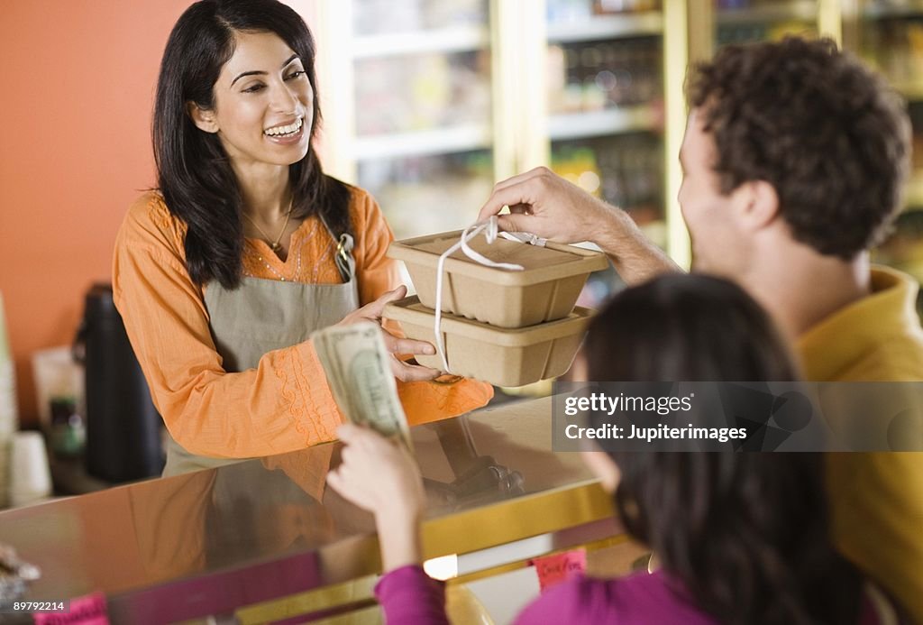 Woman serving customers at deli counter