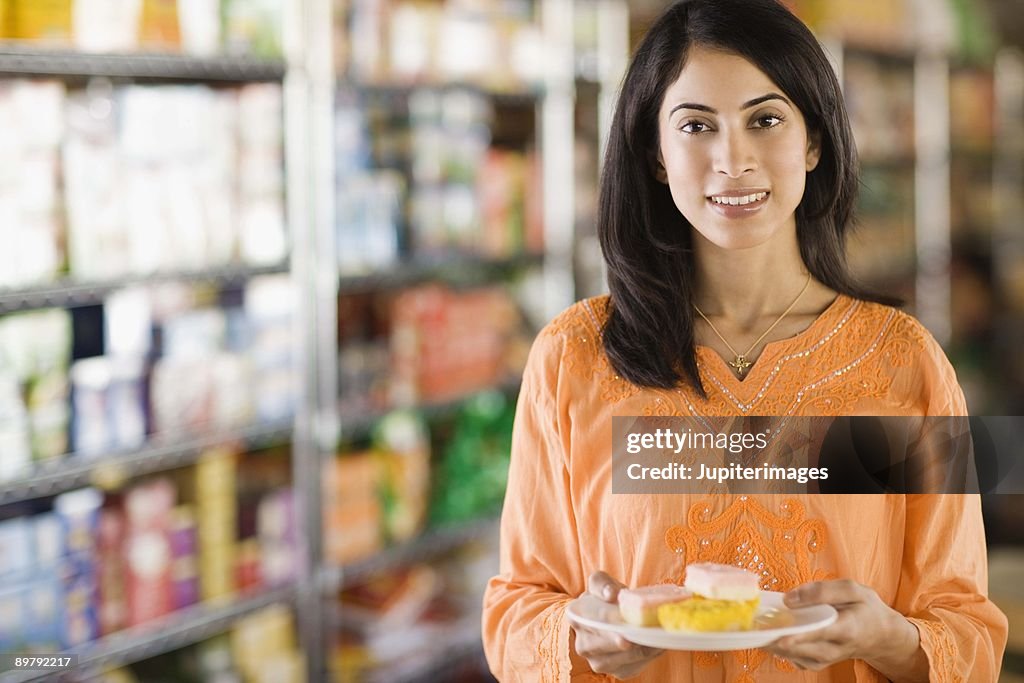 Woman holding plate of with pastries