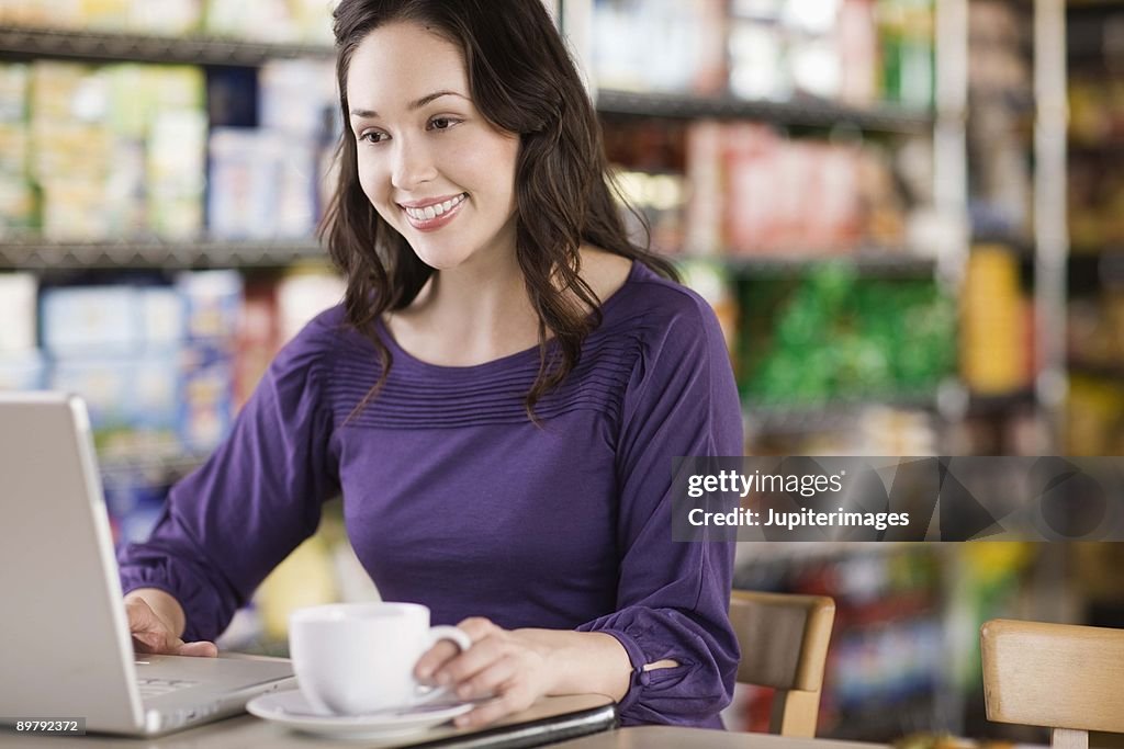 Woman using laptop in cafe