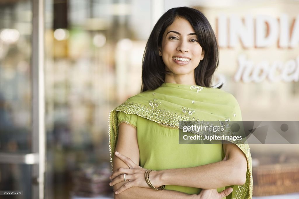 Portrait of smiling woman by storefront