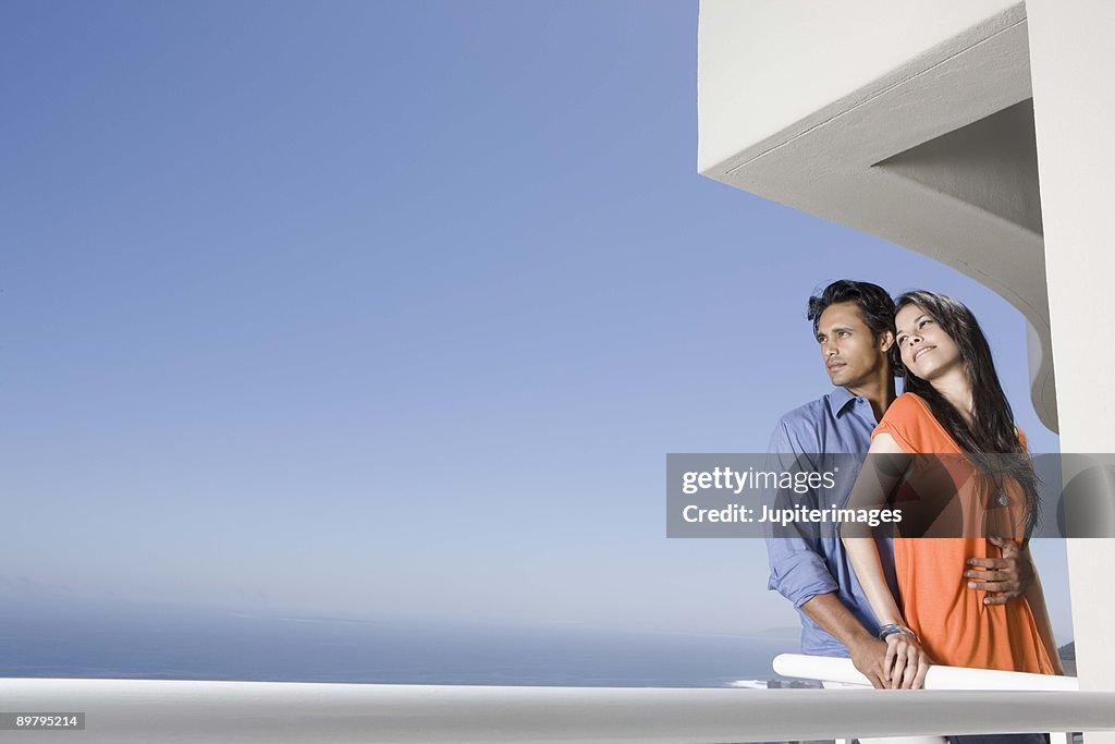 Couple standing together on balcony of hotel room