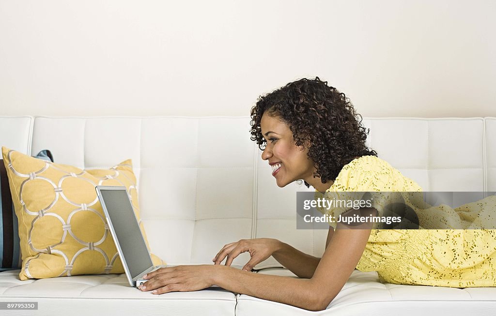 Woman with laptop on couch