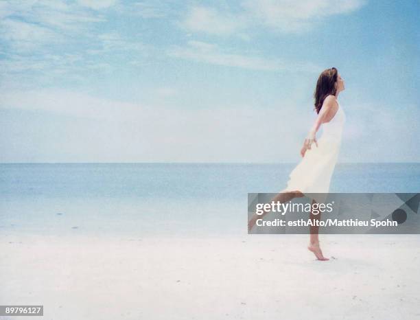 woman at beach, balancing on one leg - tiptoe stock pictures, royalty-free photos & images