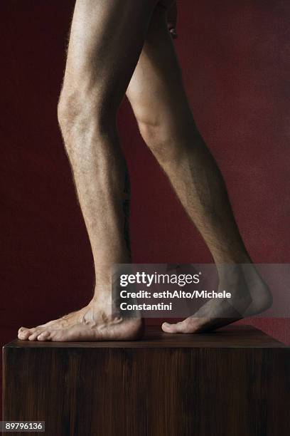 man's bare legs on pedestal, side view - barefoot men - fotografias e filmes do acervo