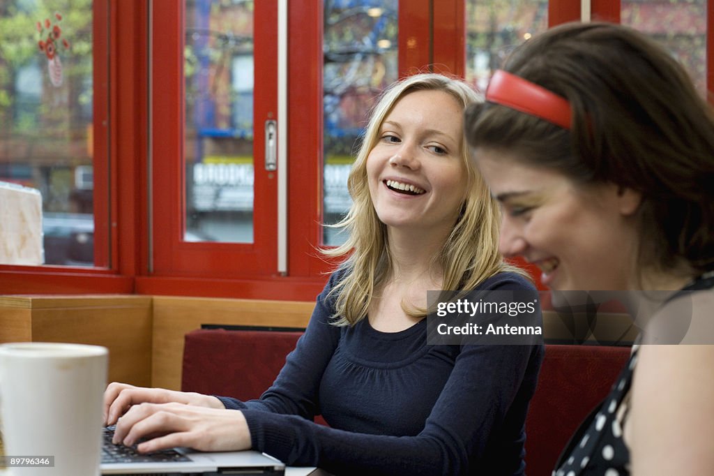 Two young women sitting in a cafe together