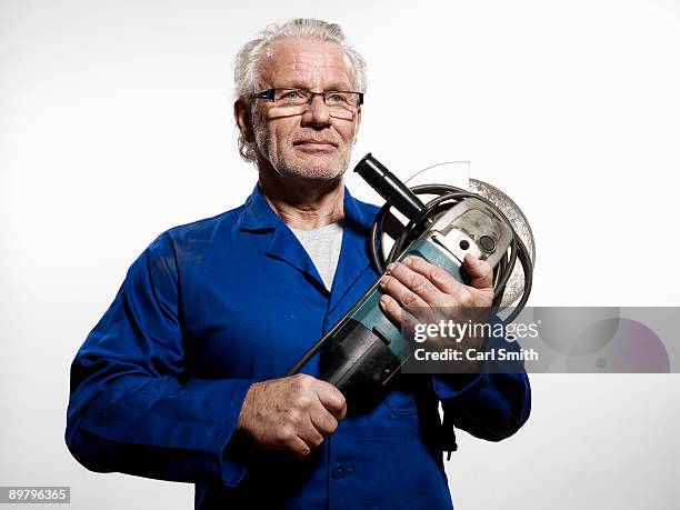 a man clutching a circular saw - elektrosäge stock-fotos und bilder