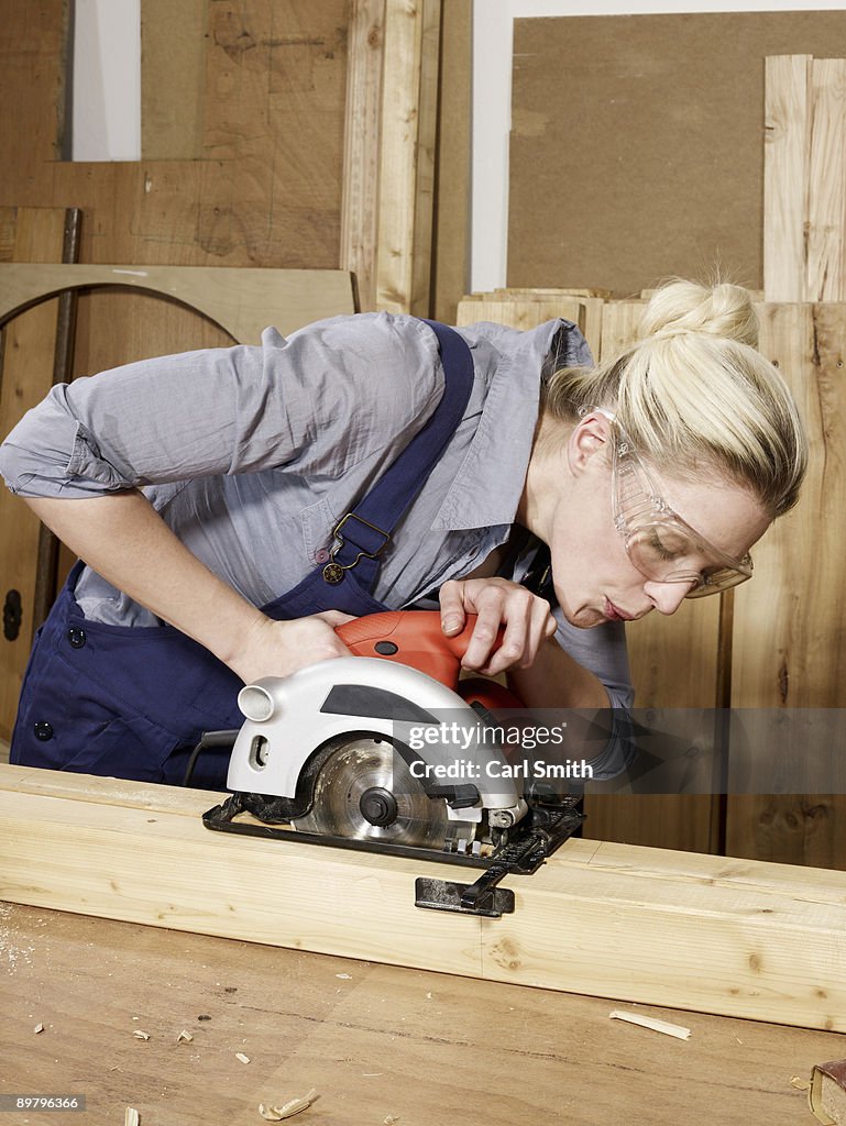 A woman sawing wood