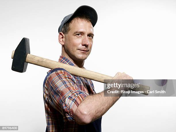 a man holding a sledgehammer over his shoulder - sledgehammer stockfoto's en -beelden