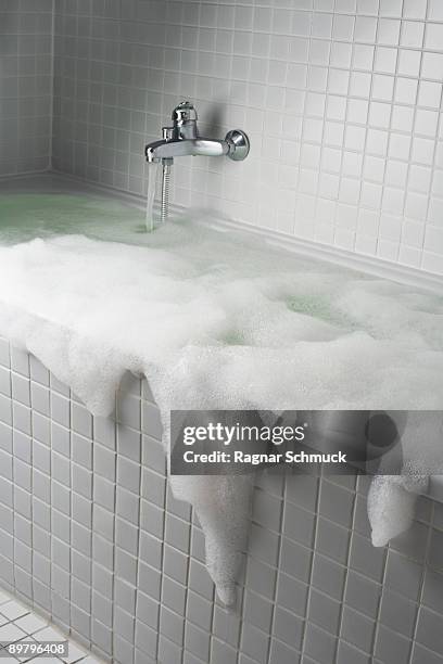 an overflowing bubble bath - derramar fotografías e imágenes de stock