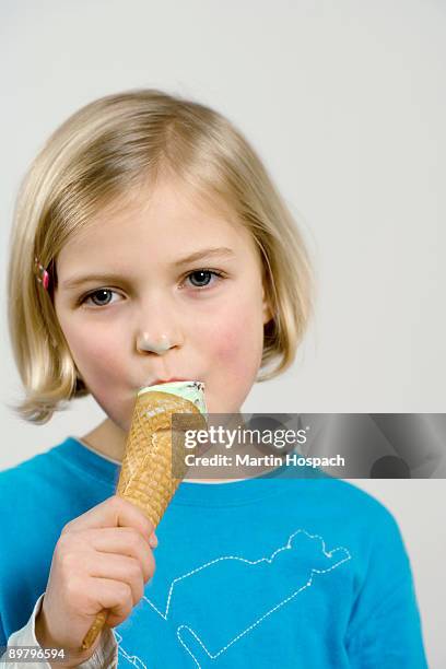 a young girl eating an ice cream cone - girl eating messy ice cream cone stock-fotos und bilder