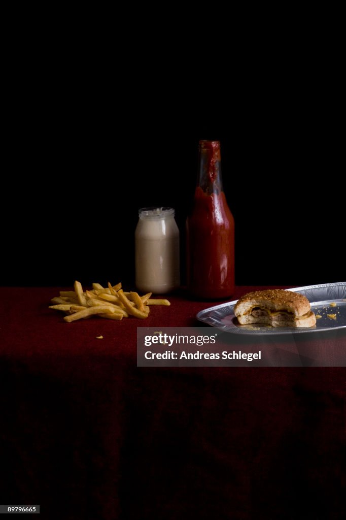 Partially eaten cheeseburger and French Fries, still life