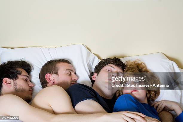 four friends lying in a bed together - promiscuïteit stockfoto's en -beelden