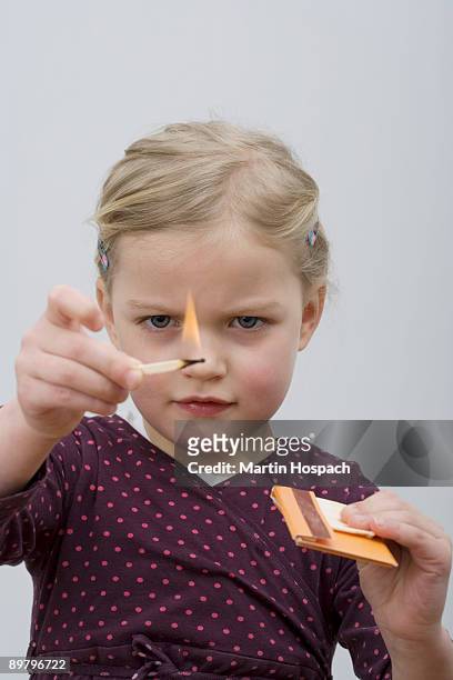 a young girl playing with matches - burning match stock pictures, royalty-free photos & images