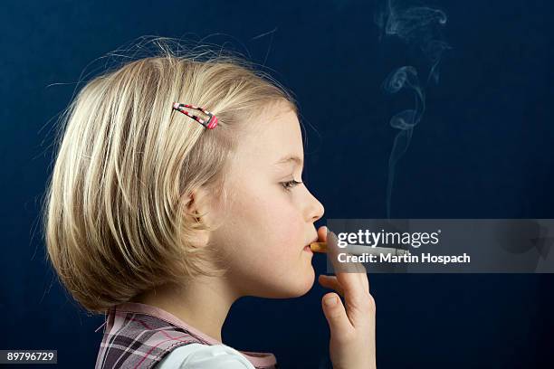 a young girl smoking a cigarette - rookkwestie stockfoto's en -beelden