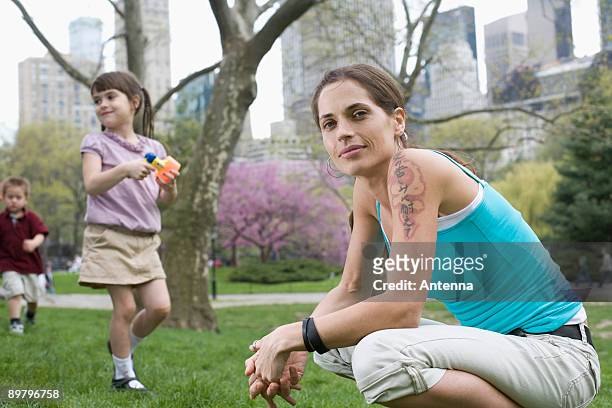 a woman and her children in central park, new york city - native korean stock-fotos und bilder