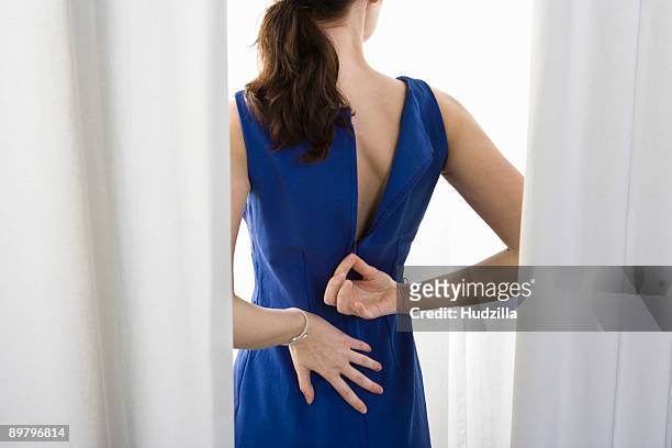 a woman trying on a dress - blue dress fotografías e imágenes de stock