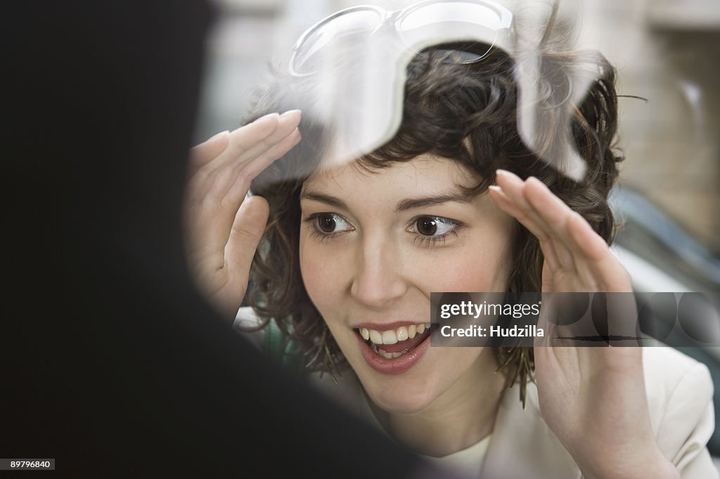 A woman looking excited through a store window