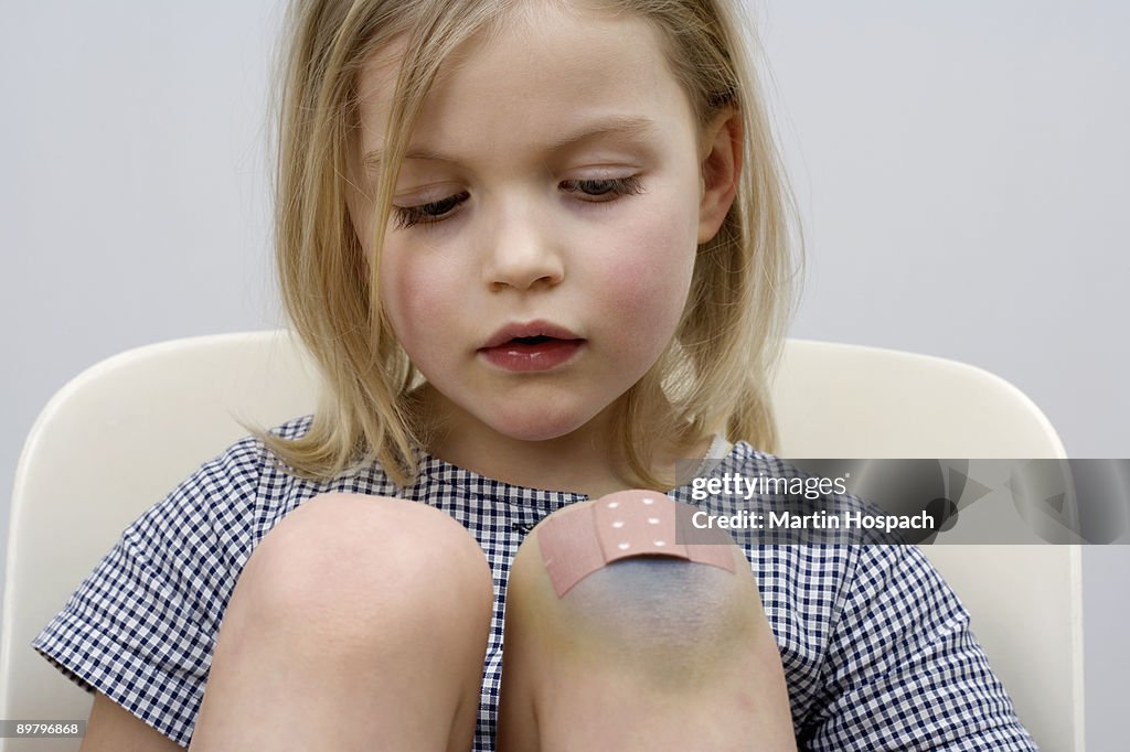 A young girl with a adhesive bandage on her knee