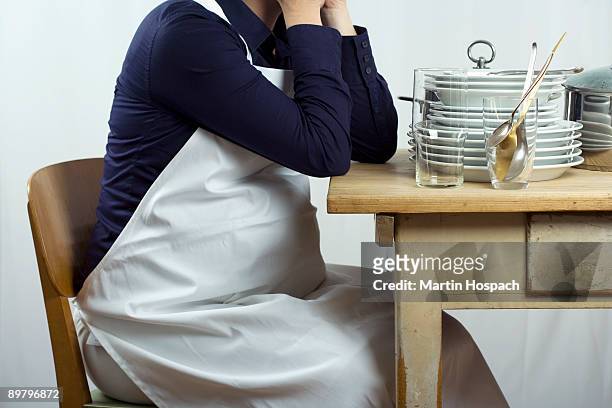 a pregnant woman sitting a table stacked with dishes - femme bras tendu cuillère photos et images de collection