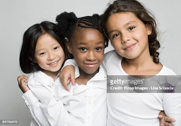 portrait of three girls embracing each other - sólo niñas fotografías e imágenes de stock