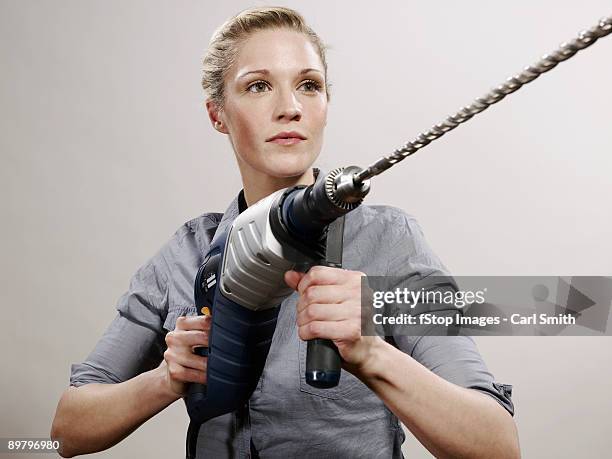 a woman holding a large drill - satire stock pictures, royalty-free photos & images