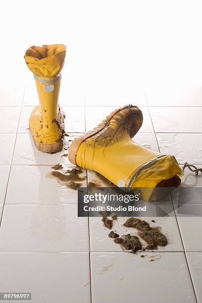 a pair of muddy rubber boots - mud floor stock pictures, royalty-free photos & images