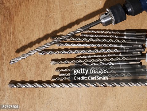 A drill and assorted drill bits on a bench A drill and assorted drill bits on a bench