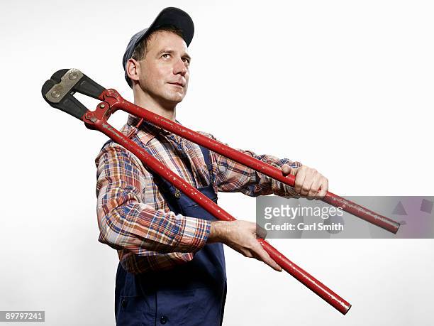 a man holding bolt cutters over his shoulder - bolt cutter stock pictures, royalty-free photos & images