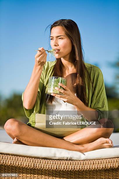 woman sitting on a mattress and eating bean sprouts - bean sprout stock pictures, royalty-free photos & images