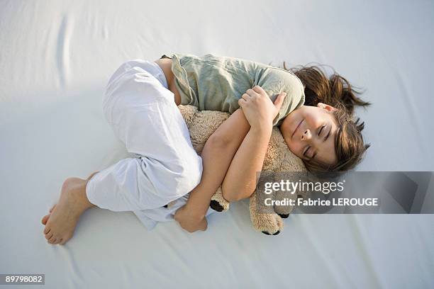 high angle view of a girl sleeping with a teddy bear - kid lying down stock pictures, royalty-free photos & images