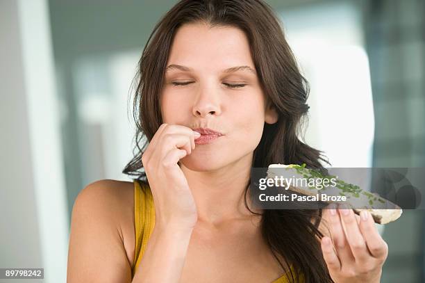 close-up of a woman eating a bread - tasting - fotografias e filmes do acervo